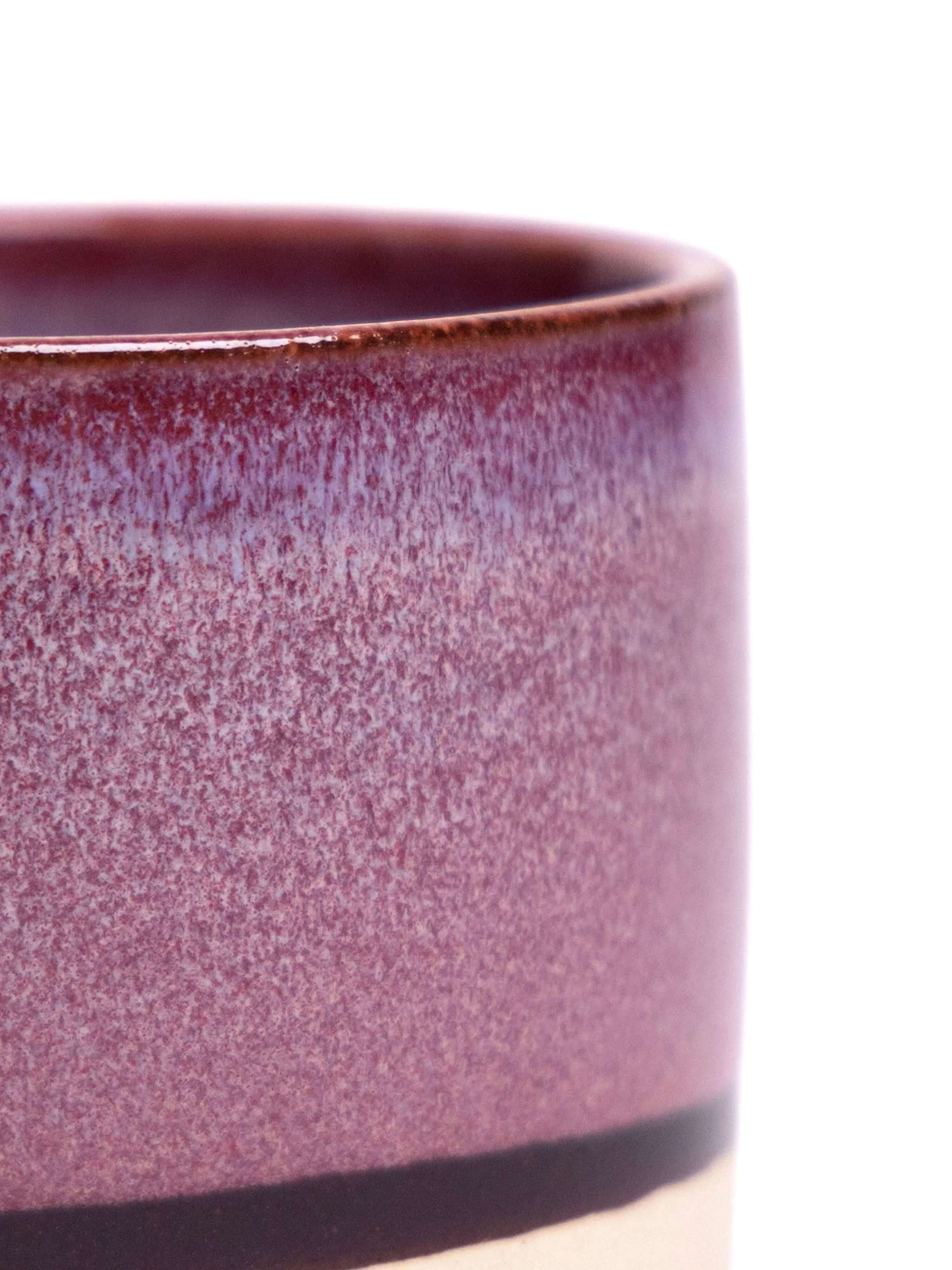 A handmade ceramic plant pot with matching saucer featuring pink and cream glazed finishes with dark accent bands, displayed against a white background