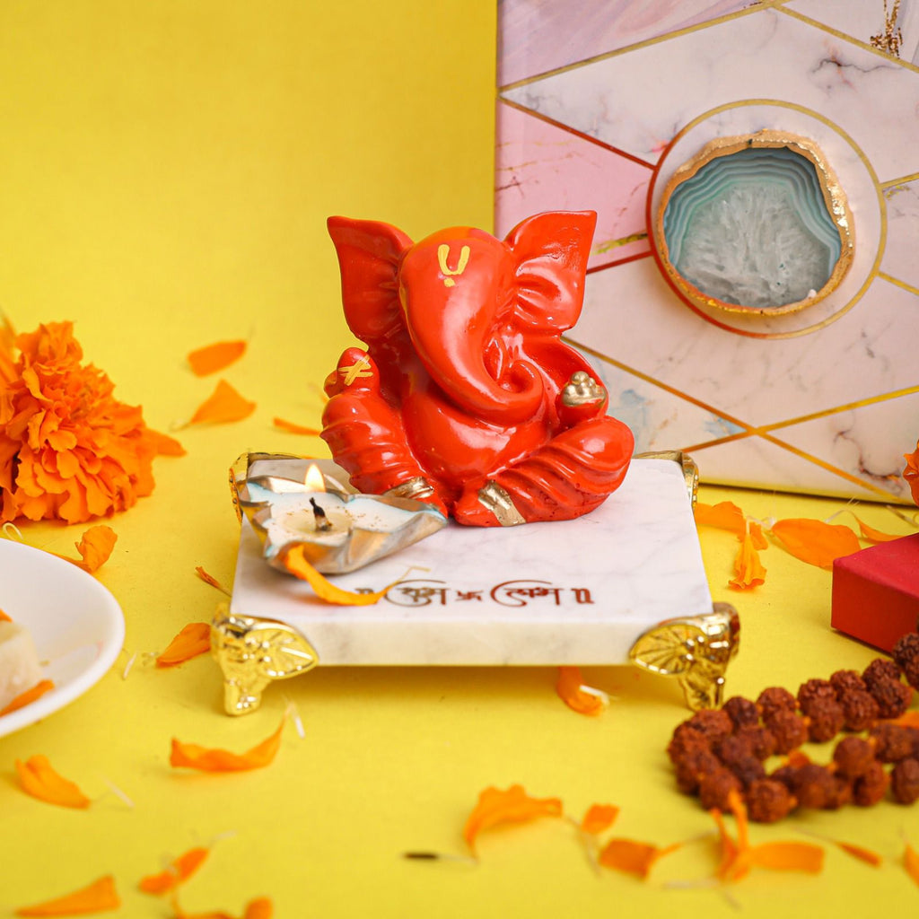 Orange Ganesha on Marble Chowki
