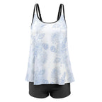 White tank top with blue floral pattern and black shorts on a white background