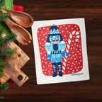 Blue Nutcracker Swedish Dishcloth | Red background with snow Swedish Dishcloths La Vie Bien Blue Nutcracker Swedish Dishcloth | Red background with snow