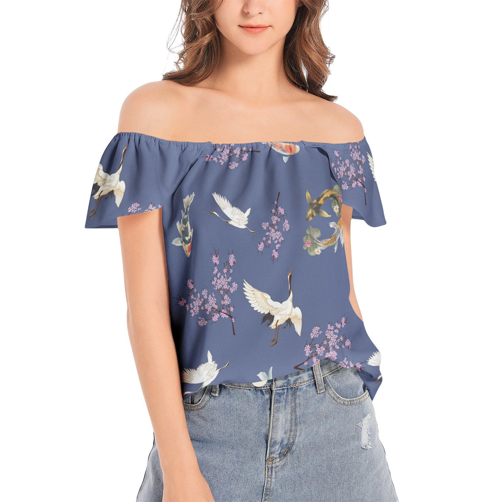 Woman wearing a blue off-shoulder top with bird and floral pattern on a white background