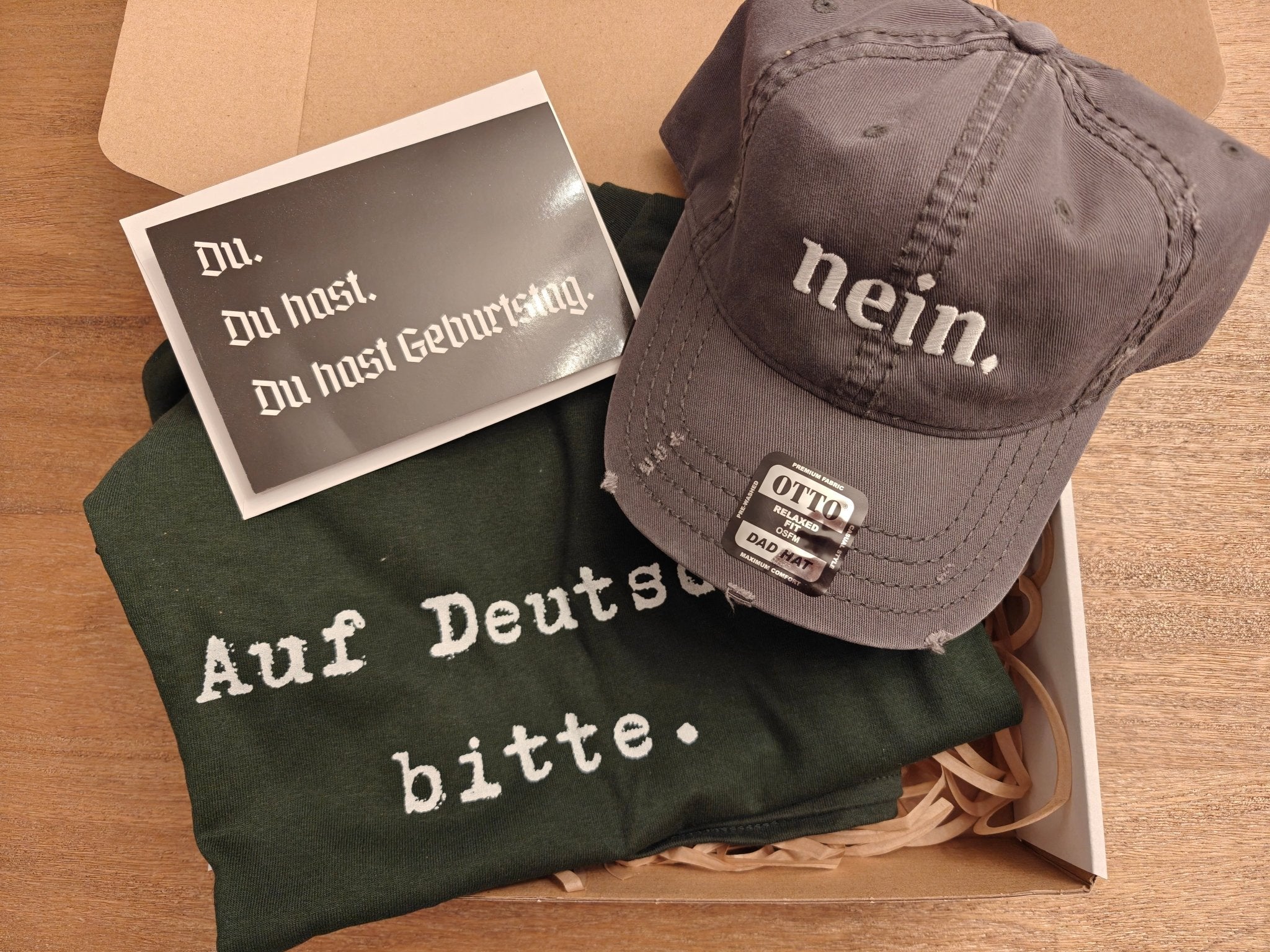 German Birthday Gift Box | Funny German Gift Set | Auf Deutsch Bitte Tee + Nein Dad Hat + Du Hast Geburtstag Card Bundle Gift Sets La Vie Bien German Birthday Gift Box | Funny German Gift Set | Auf Deutsch Bitte Tee + Nein Dad Hat + Du Hast Geburtstag Card
