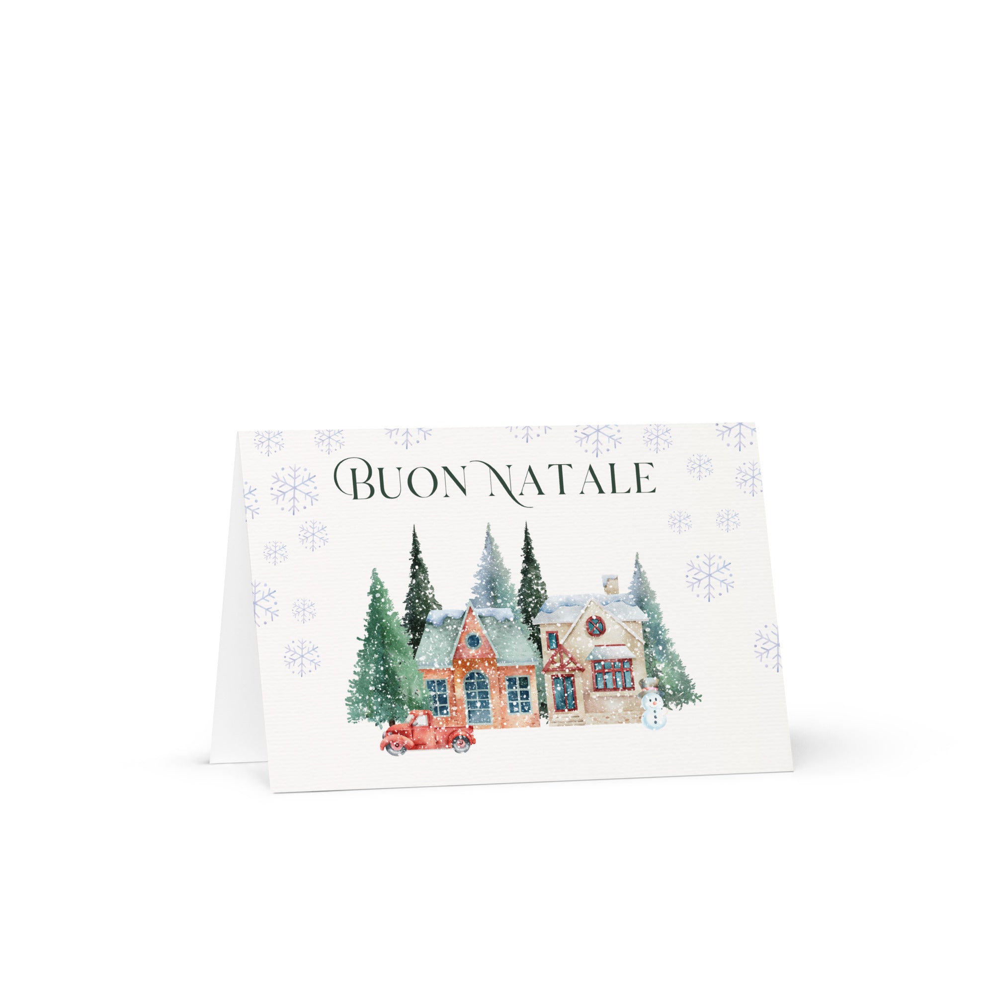Italian Christmas greeting card featuring "Buon Natale" text with watercolor illustration of snowy village scene with cottages, pine trees, snowman, and vintage truck surrounded by delicate snowflake pattern