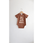 Hi, I'm New Here Baby Onesie in Almond by Polished Prints