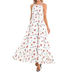 A woman modeling a sleeveless halter-neck maxi dress with an allover print of red lips and black Japanese katakana text on a white background, paired with black heeled sandals.