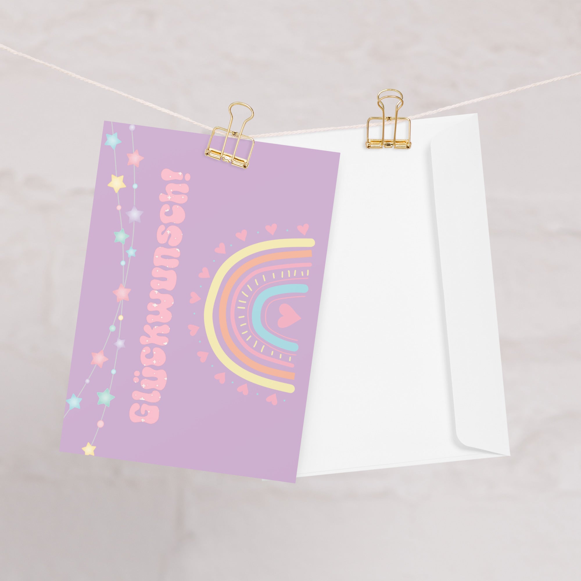 German greeting card with purple background featuring "Glückwunsch!" text in pink bubble letters, decorated with a pastel rainbow, colorful star garland, and small heart details