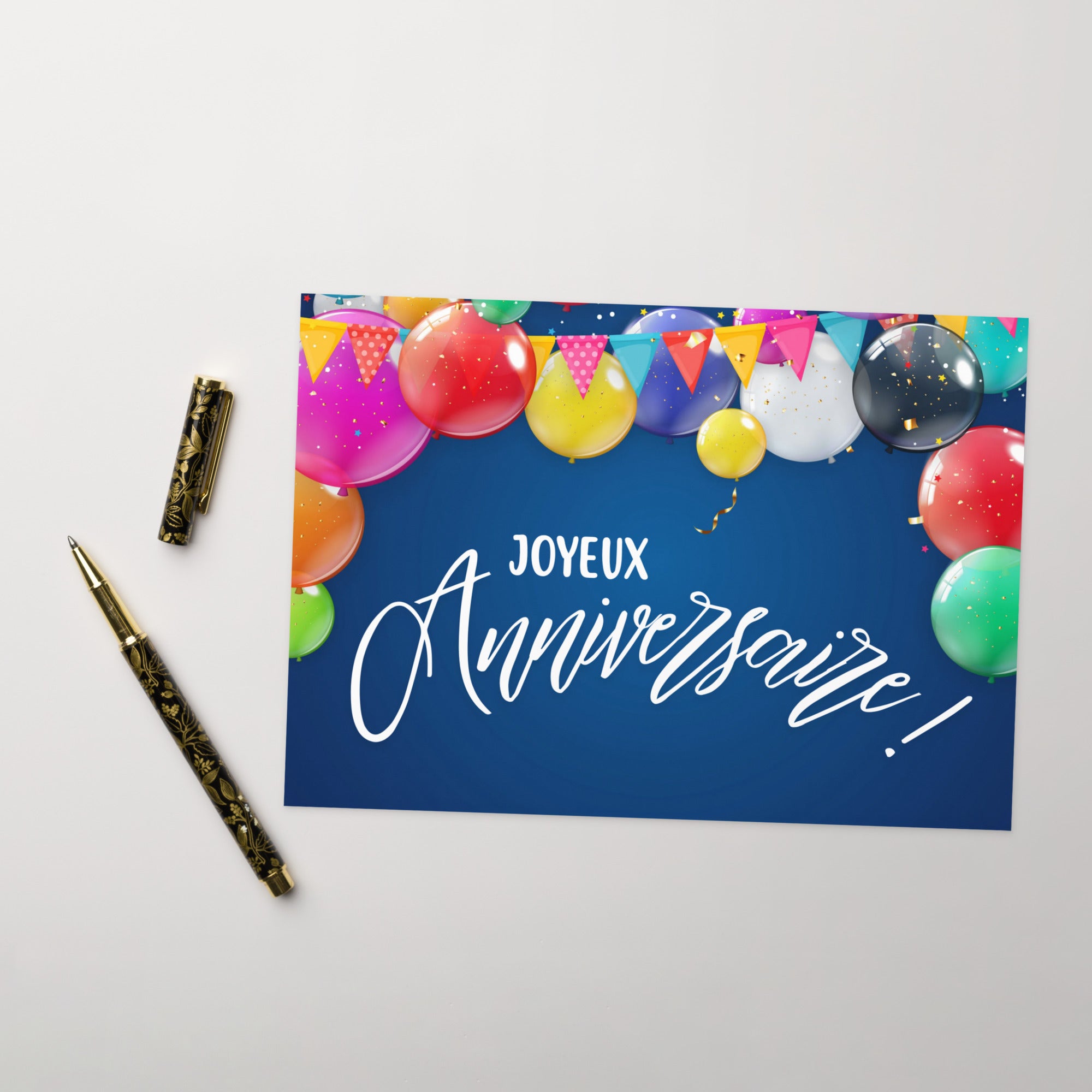 French birthday greeting card featuring "Joyeux Anniversaire" text in white script on navy blue background, decorated with colorful balloons in pink, red, yellow, green, purple, and blue, along with festive bunting banners and confetti