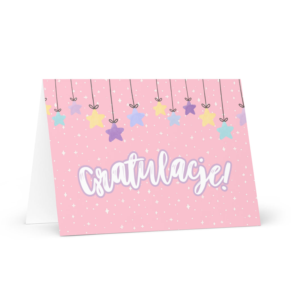 Polish greeting card with pink background featuring "Gratulacje!" text in white script lettering, decorated with hanging colorful stars and small sparkle details throughout