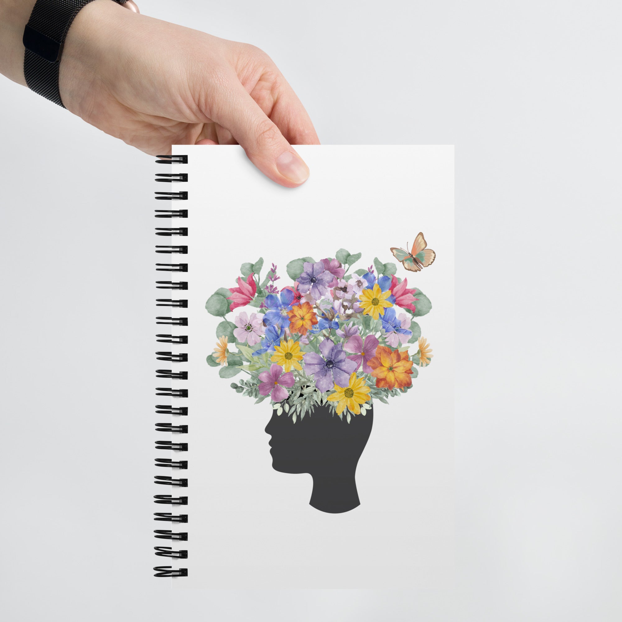 An image of the Spiral dotted notebook and a graphic of a head with flowers coming out of the top
