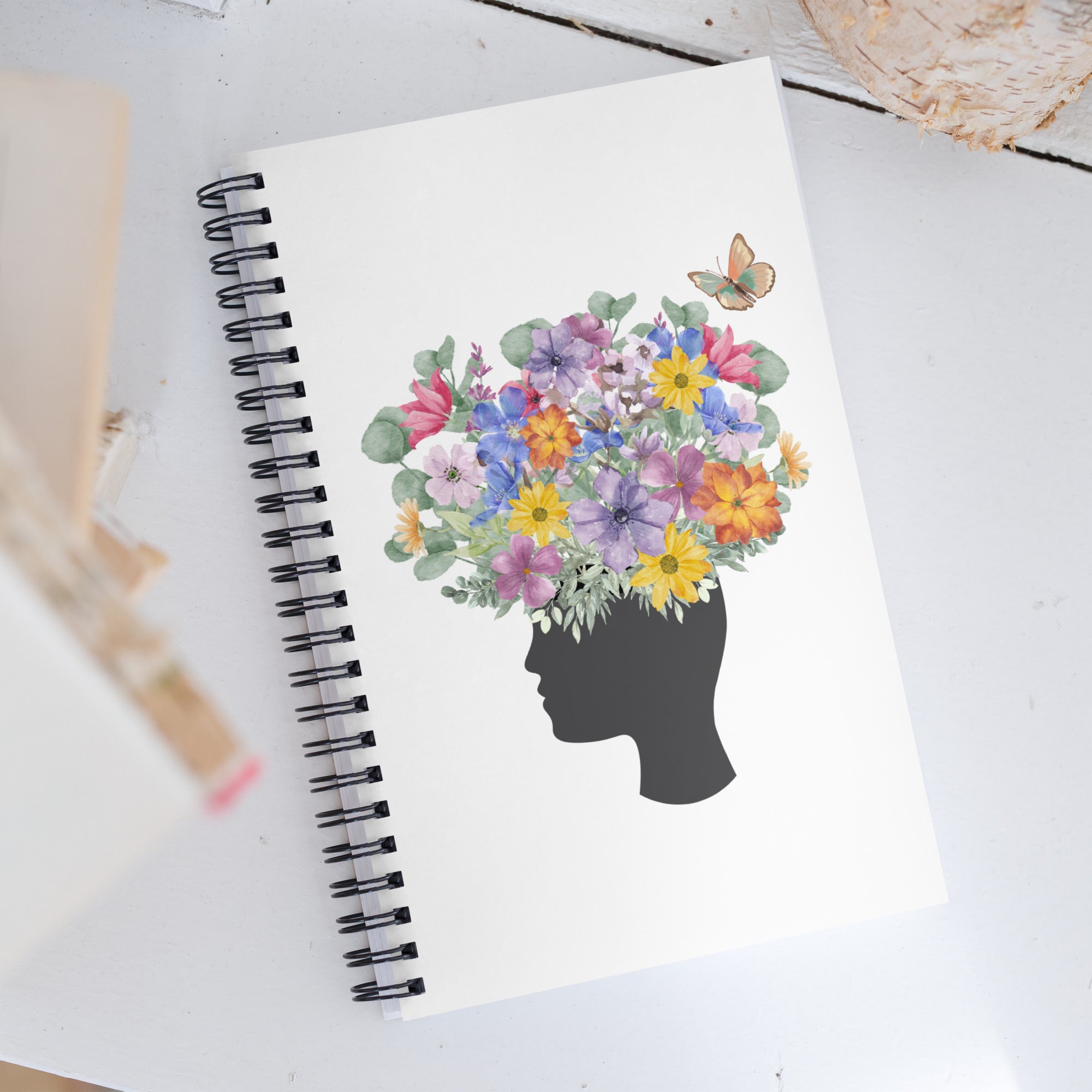 An image of the Spiral dotted notebook and a graphic of a head with flowers coming out of the top