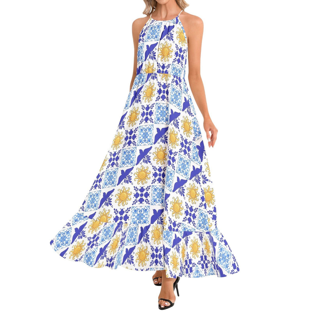 A sleeveless halter-neck maxi dress with a blue, white, and yellow geometric tile pattern, shown on a model against a plain white background.