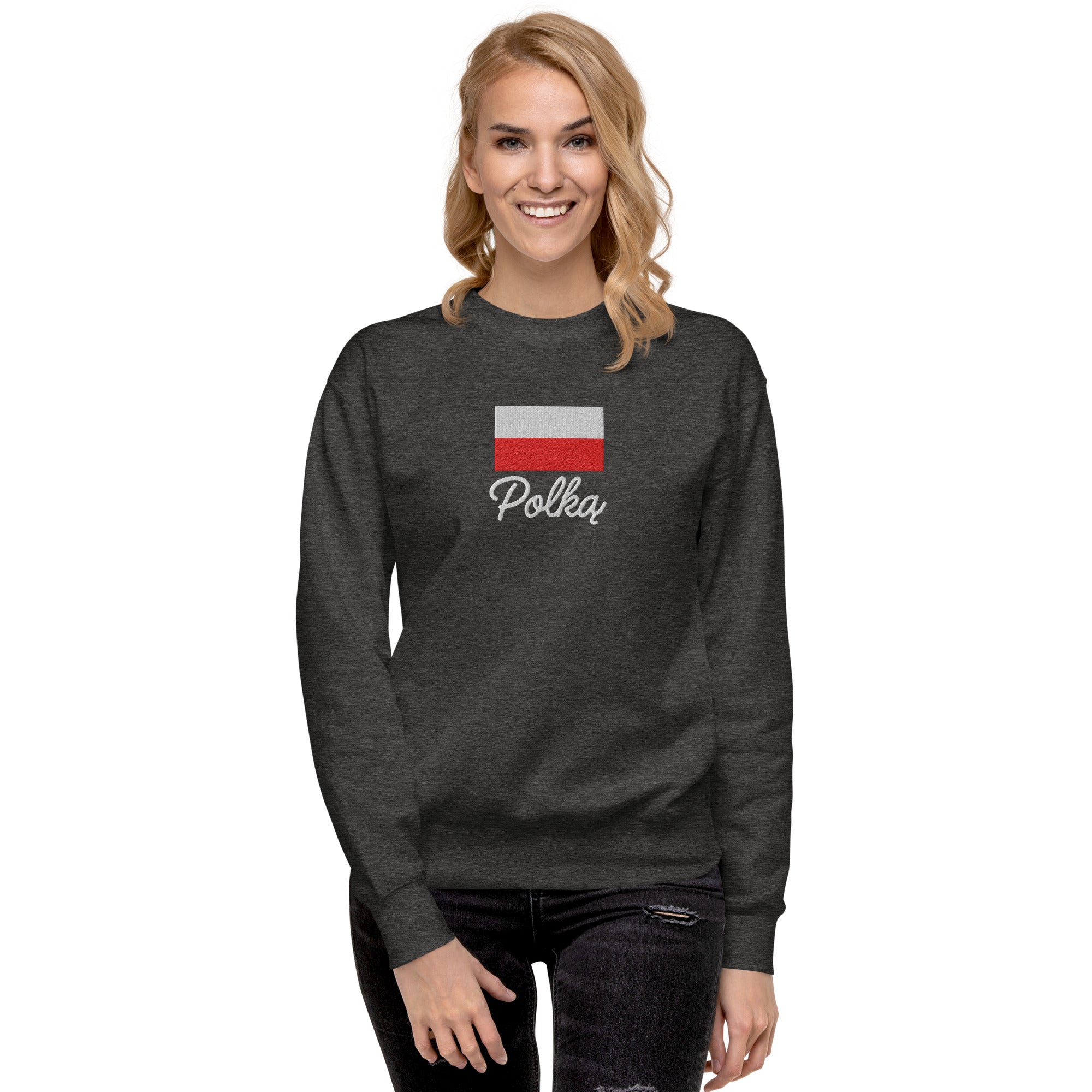 Dark gray crew neck sweatshirt modeled on person, featuring embroidered Polish flag in white and red colors above white embroidered text "Polka" in script font